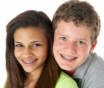 A boy and girl teen wearing braces