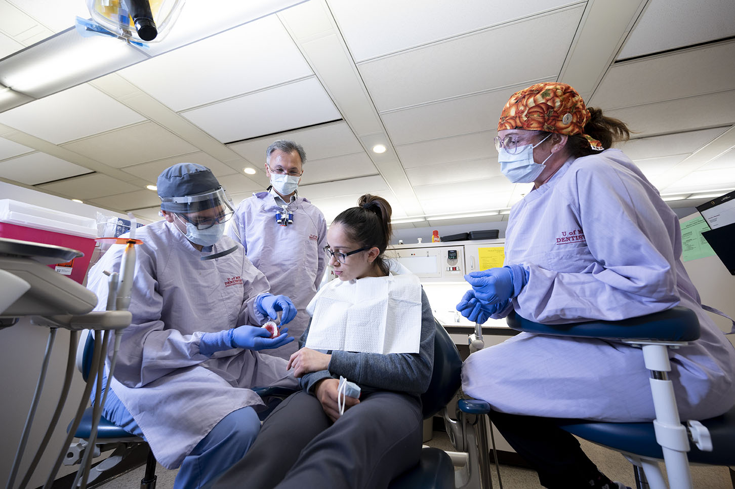 Graduate Prosthodontics faculty and residents consult with a patient
