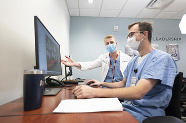 Oral and maxillofacial surgery lab technicians working at a computer